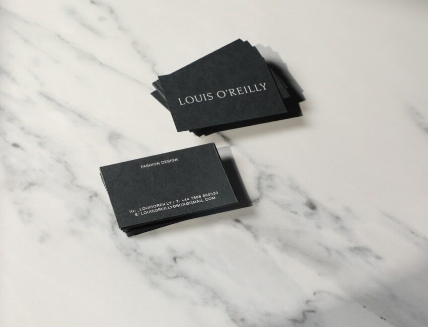 Two business cards resting on a marble counter